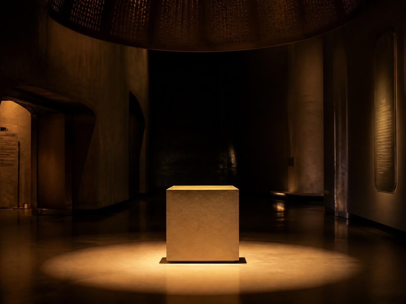 Illuminated stone pedestal in a darkened gallery